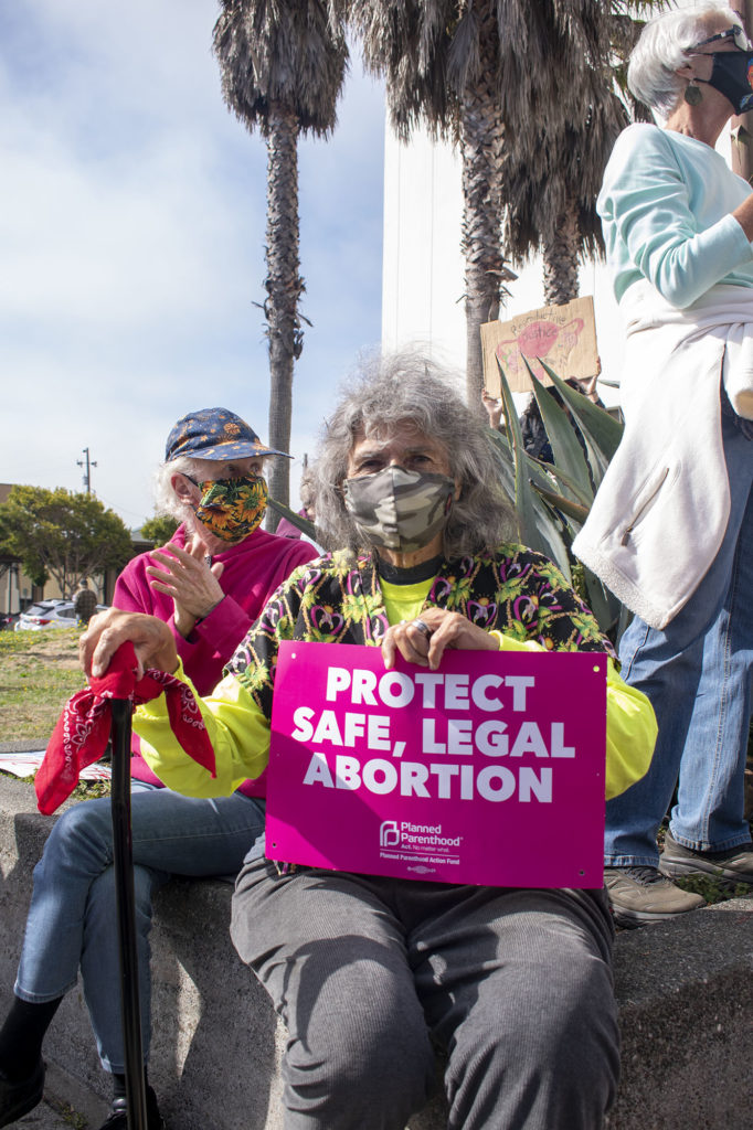 Holly Kingel holds a sign reading 'protect safe, legal abortion'.