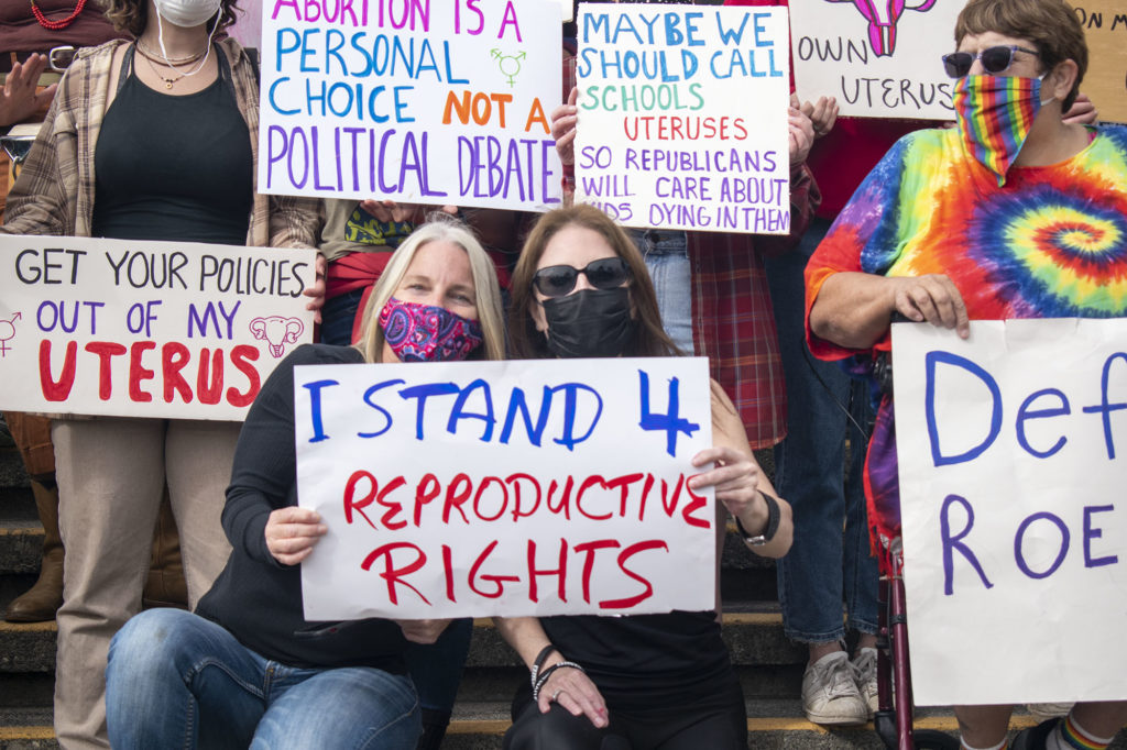 Kim Bergel and Michele Walford hold a sign that says "I stand 4 reproductive rights".
