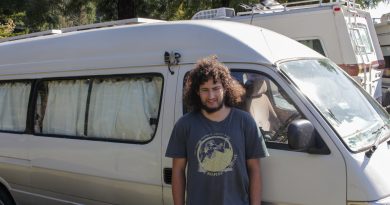 Ryan Kelly, a student at Cal Poly Humboldt, stands next to the van that he lives in.