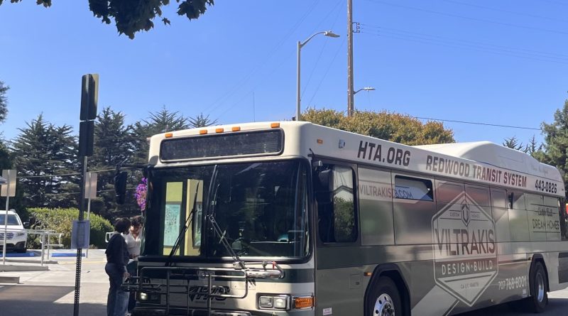 Picture of HTA bus at library circle with students waiting to board.