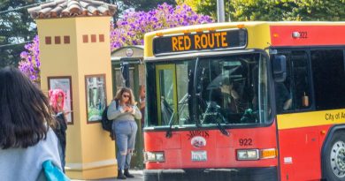 Photo of bus red route and students standing nearby.